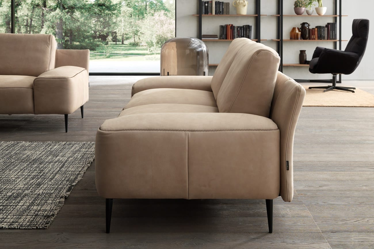 Wohnambiente mit dem 2.5er-Sofa des Modells Forma mit beigem Lederbezug, Kontrastnaht und mattschwarzen Füssen