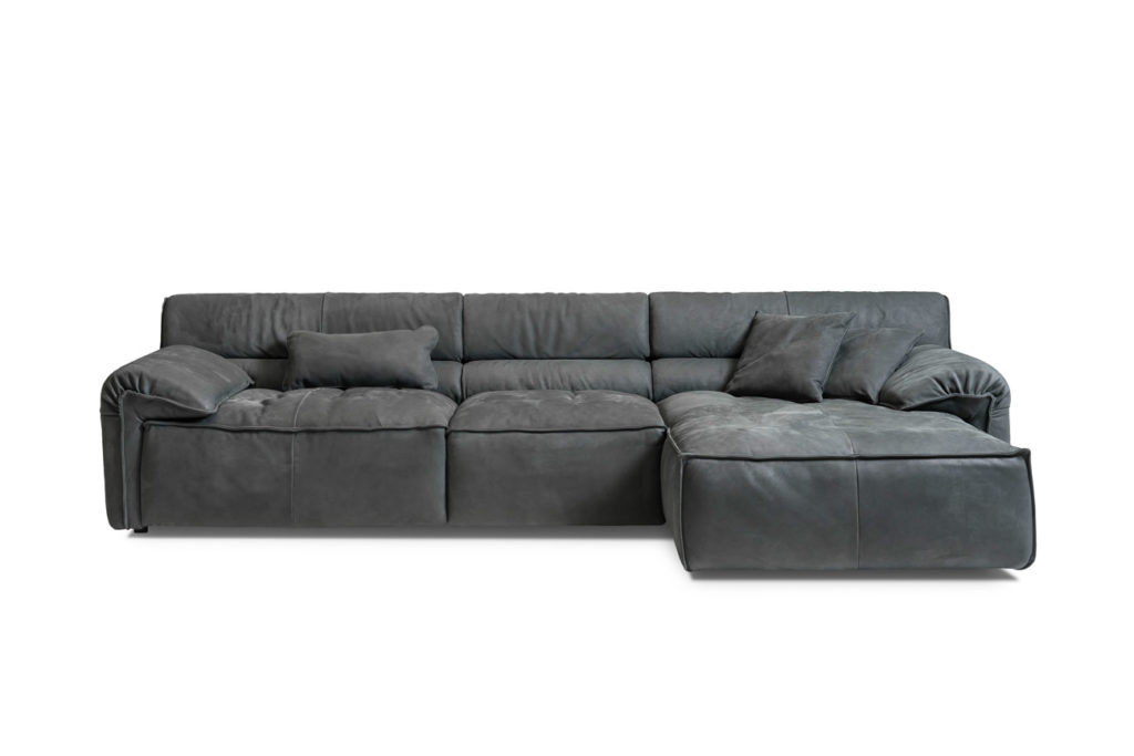 Sofakombination des Modells Vola mit grauem Lederbezug, Nierenkissen, Wurfkissen und schwarzen Kunststoffgleitern